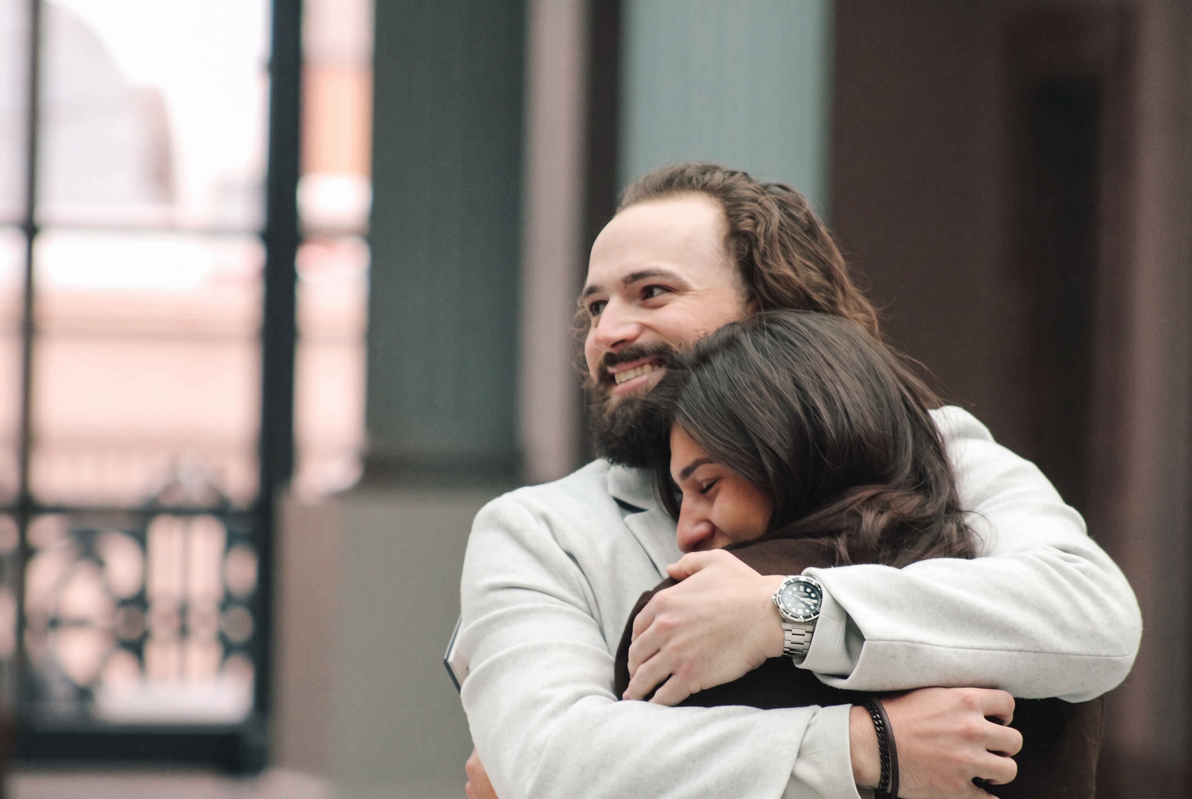 Nick smiling as Mariella nestles into his arms
