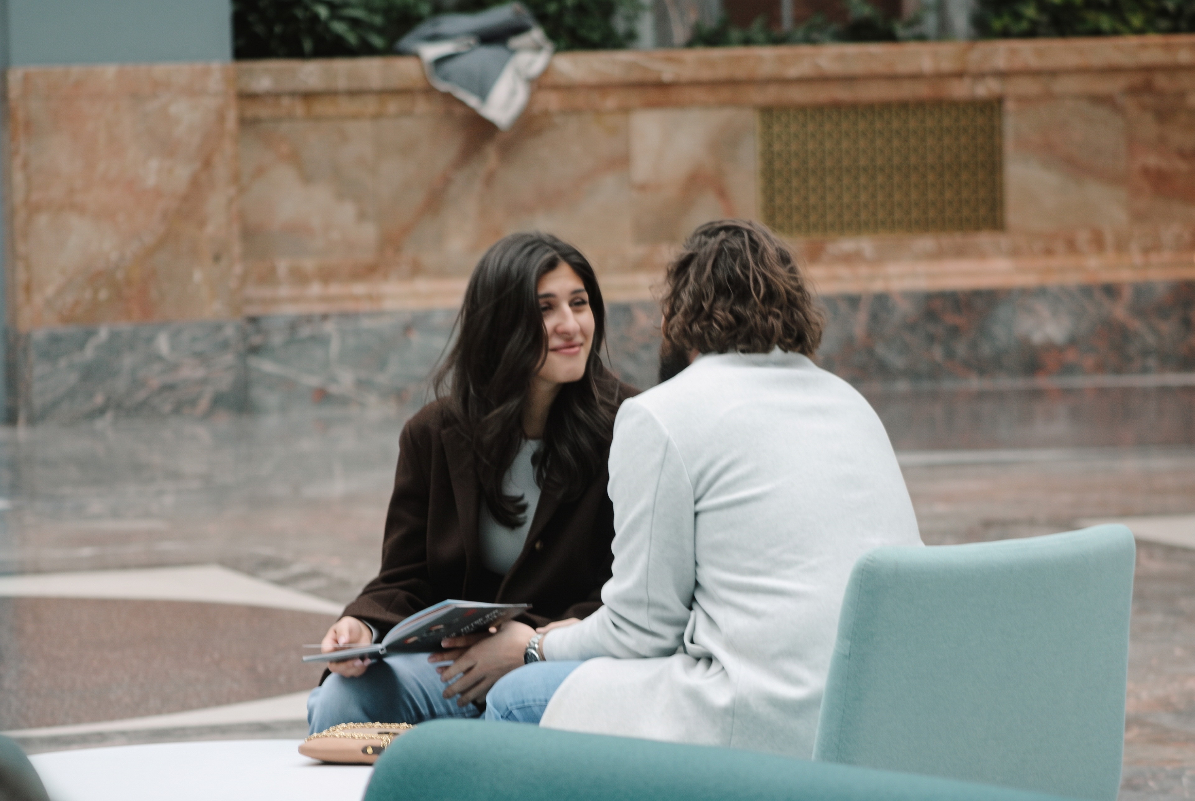 Mariella and Nick facing each other while seated with a book