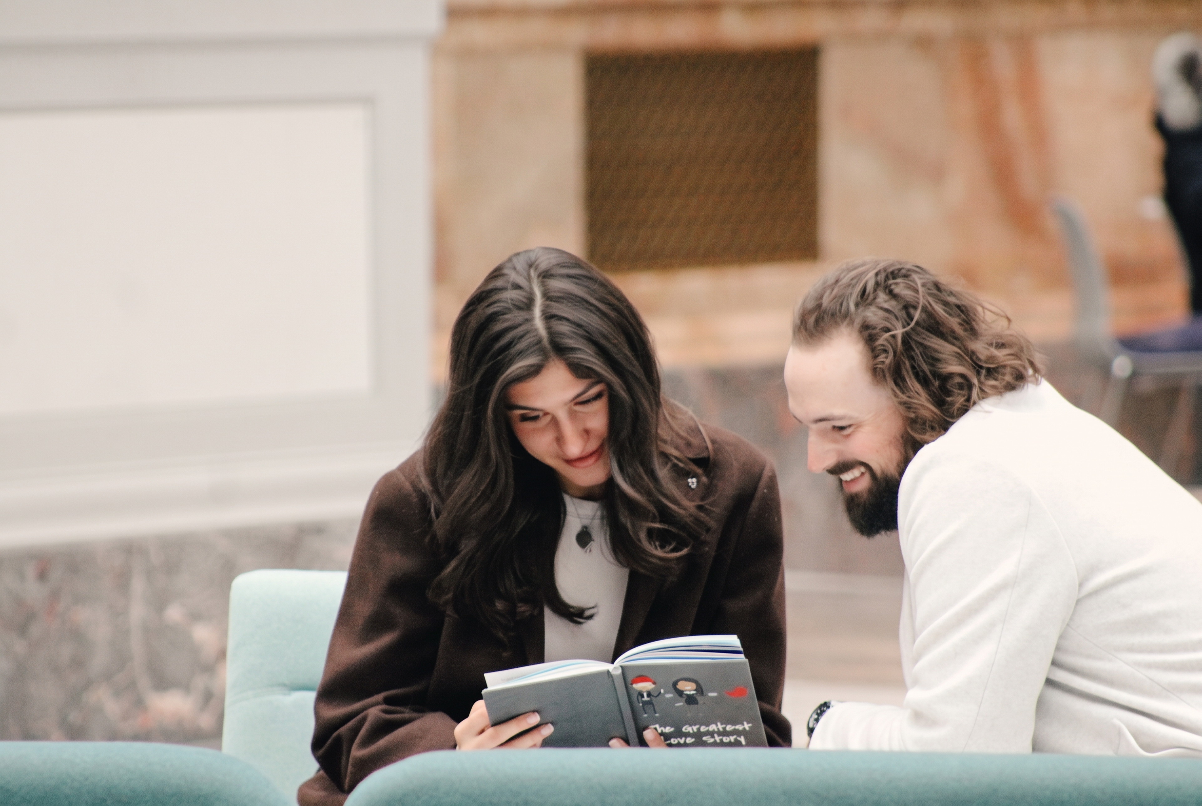 Nick and Mariella leaning in together over a book